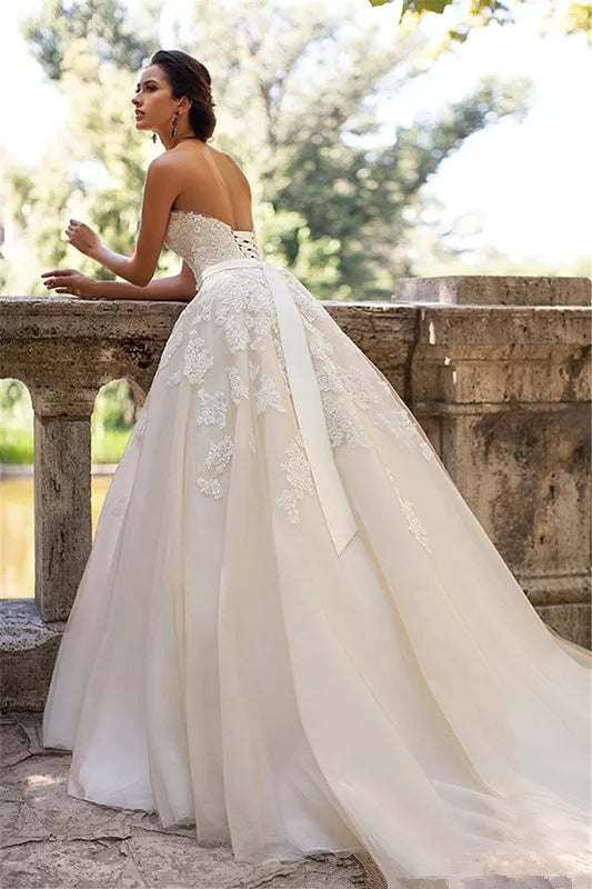 Vestido de novia en escote strapless y lazo largo con cinturón