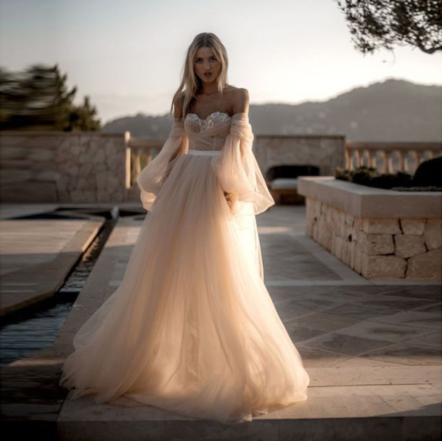 Vestido de novia con mangas abullonadas y escote strapless, de tul corte A