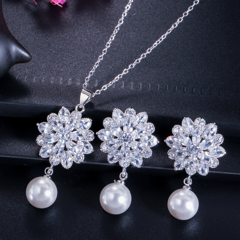 Elegante set de joyería para novias. Aretes de flores y perlas y collar de zirconias