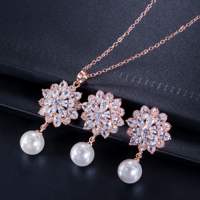 Elegante set de joyería para novias. Aretes de flores y perlas y collar de zirconias