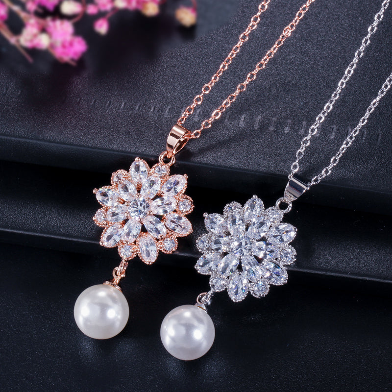 Elegante set de joyería para novias. Aretes de flores y perlas y collar de zirconias