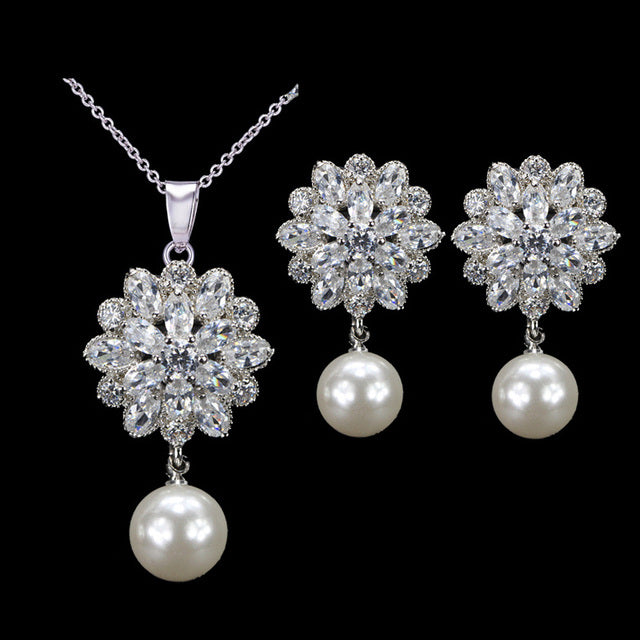 Elegante set de joyería para novias. Aretes de flores y perlas y collar de zirconias